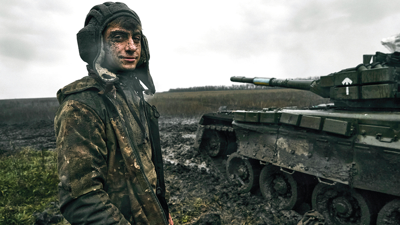 جندي أوكراني يقف بجانب دبابة روسية مدمّرة.   أ.ب