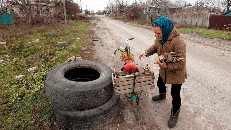 سيدة أوكرانية تحاول جمع الحطب لغرض التدفئة.أ.ف.ب