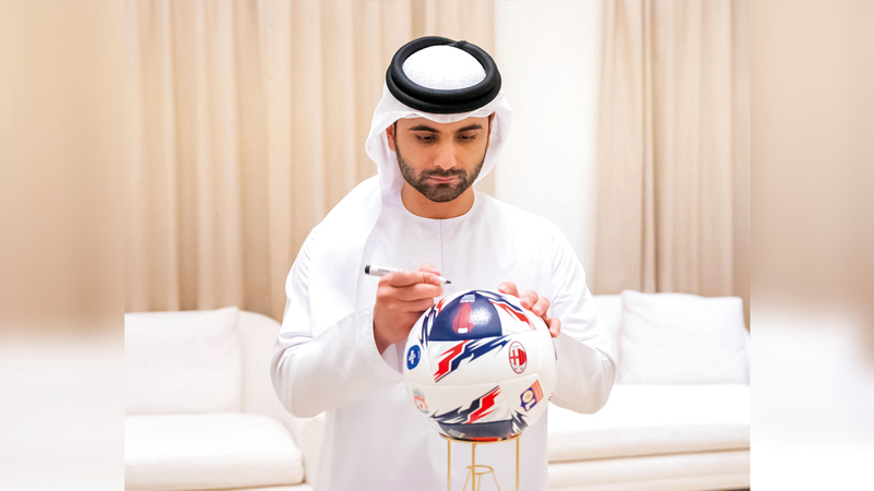 منصور بن محمد يوقّع على كرة بطولة «كأس سوبر دبي 2022». من المصدر