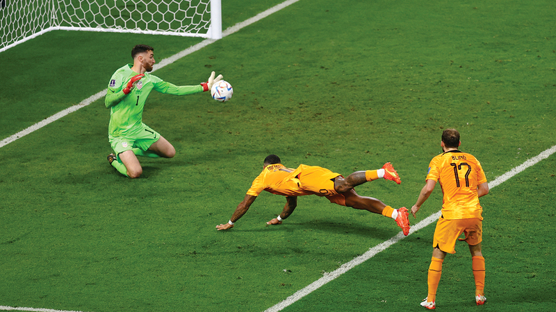 ممفيس ديباي يغمز الكرة نحو المرمى الأميركي. إي.بي.إيه