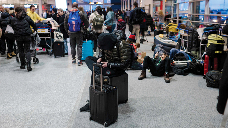مسافرون ينتظرون في مطار بيير إليوت ترودو الدولي في مونتريال مع تساقط الثلوج.   أ.ف.ب