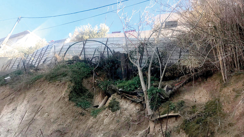 منازل عائلتي أبوتايه والعباسي المتضرّرة أعلى الجدار. À الإمارات اليوم