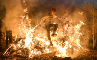 الصورة: تقاليد القفز على النار في الصين.. بالصور