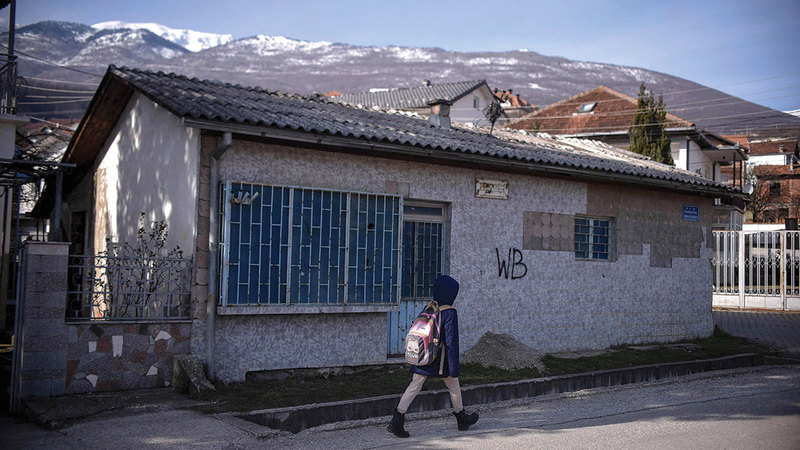 طفلة تمر قبالة مقهى مغلق ضمن كثير من المرافق التي أغلقت في بيا بسبب الاضطرابات القديمة.   أ.ف.ب