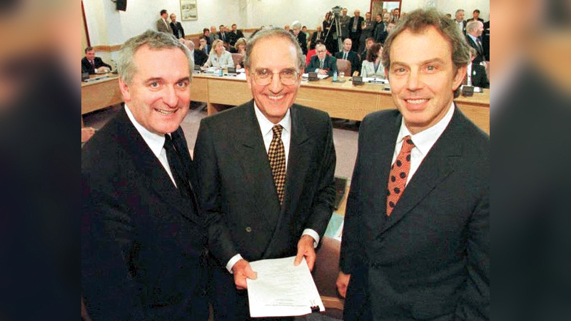 بلير وأهيرن يتوسطهما المبعوث الخاص للإدارة الأميركية جورج ميتشل بعد توقيع اتفاق الجمعة العظيمة الذي أسفر عن تحقيق السلام في إيرلندا الشمالية. أرشيفية