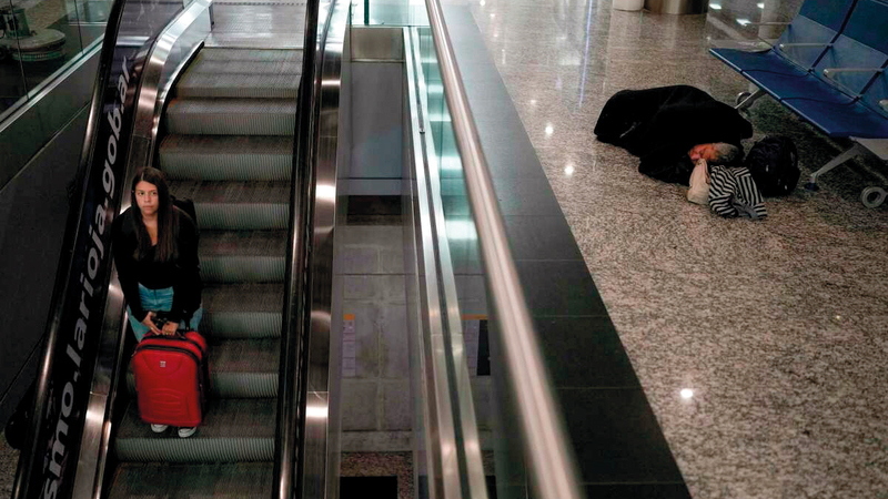أشخاص ينامون على الكراسي والأرض في المطار. أرشيفية