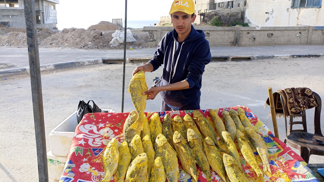 الشاب محمود خليفة يجد في بيع الفسيخ مصدر رزق موسمي مؤقت.