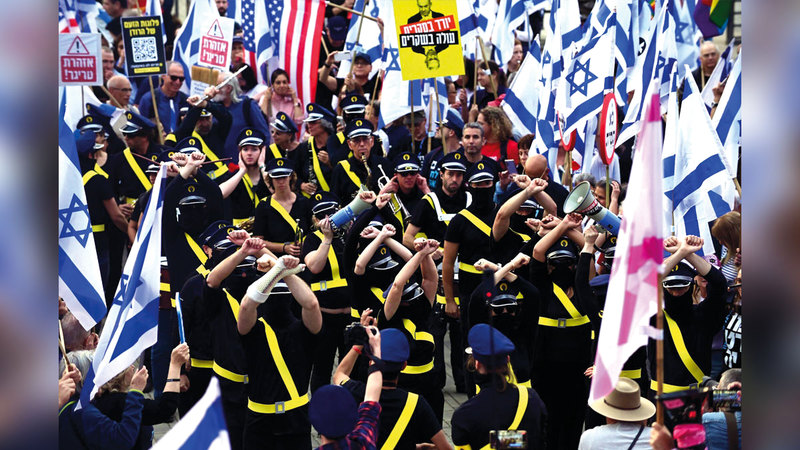 متظاهرون إسرائيليون يؤدون حركة طلب المساعدة من إخوانهم الأميركيين المؤيدين للديمقراطية. عن صحيفة «تايمز أوف إسرائيل »