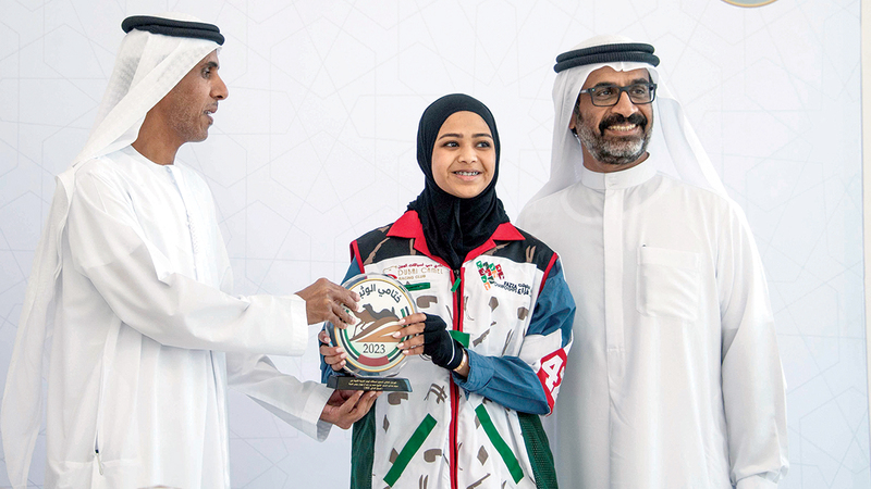 بطلة السباق الإماراتية حمدة أثناء التتويج من قِبل عبدالله مبارك المهيري وبحضور عبدالله حمدان بن دلموك.  من المصدر