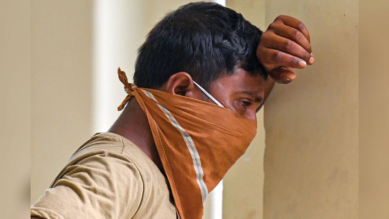 يبكي بعد تثبّته من فقدان أحد أفراد عائلته.   أ.ف.ب