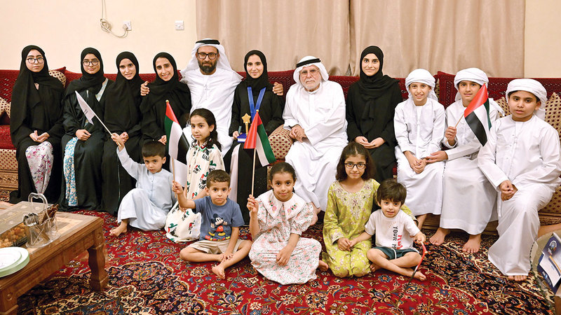 آمنة المنصوري تتوسط والدها وإخوتها وأفراداً من عائلتها الذين تلقت منهم كل الدعم والتشجيع لمواصلة طريق النجاح والتفوق.  تصوير: إريك أرازاس