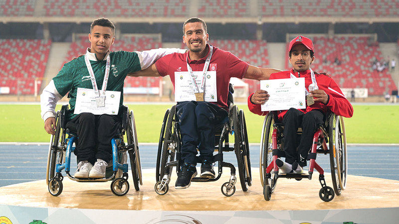 محمد المزروعي (يمين) على منصة التتويج متقلداً برونزية الكراسي المتحركة 1500 متر.   من المصدر
