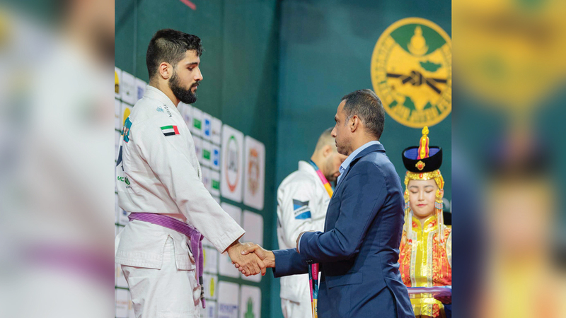 سعيد الكبيسي على منصة التتويج لتسلم فضية 85 كلغم.   من المصدر