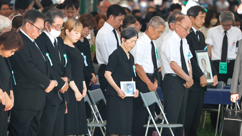 الحضور يقفون دقيقة صمت في حديقة السلام التذكارية في هيروشيما.  أ.ف.ب