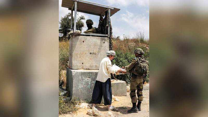 جنود الاحتلال يوفرون الحماية لعودة المستوطنين إلى حوميش.  الإمارات اليوم