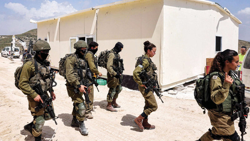 عملية بناء «حوميش» تتم بحماية أمنية مطلقة من جيش الاحتلال.  الإمارات اليوم