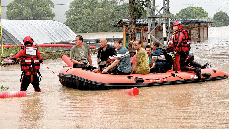 فرق إنقاذ في محافظة مينهو الصينية تنقل السكان إلى مكان آمن بعد الفيضانات التي خلفها إعصار هايكوي.   رويترز