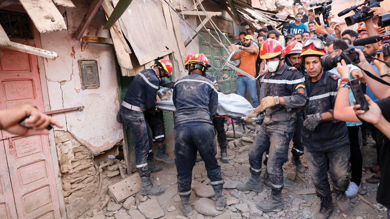 عمال الطوارئ يحملون جثة إحدى الضحايا في منطقة أمزميز.  رويترز