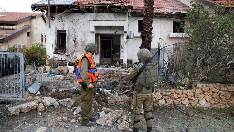 جنديان إسرائيليان يتفقدان منزلاً متضرراً في عسقلان بعد هجوم لـ&laquo;حماس&raquo;. أ.ف.ب
