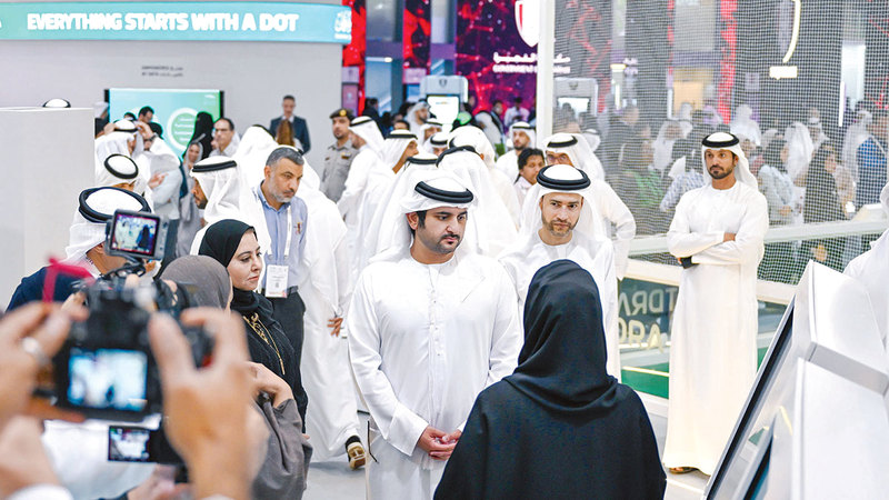 مكتوم بن محمد خلال زيارته جناح وزارة المالية في المعرض. من المصدر