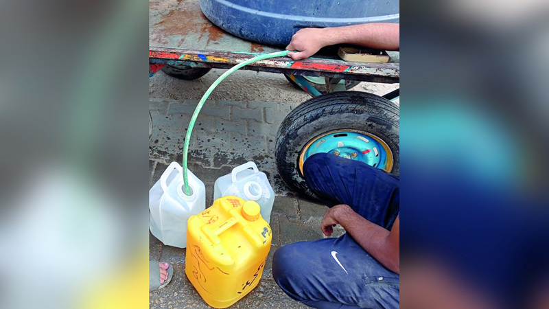 طرق تعبئة المياه تتم يدوياً عبر غالونات وأوعية بلاستيكية صغيرة. الإمارات اليوم