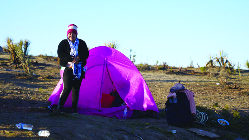مهاجرة أمام خيمتها في الهواء الطلق. إي.بي.إيه