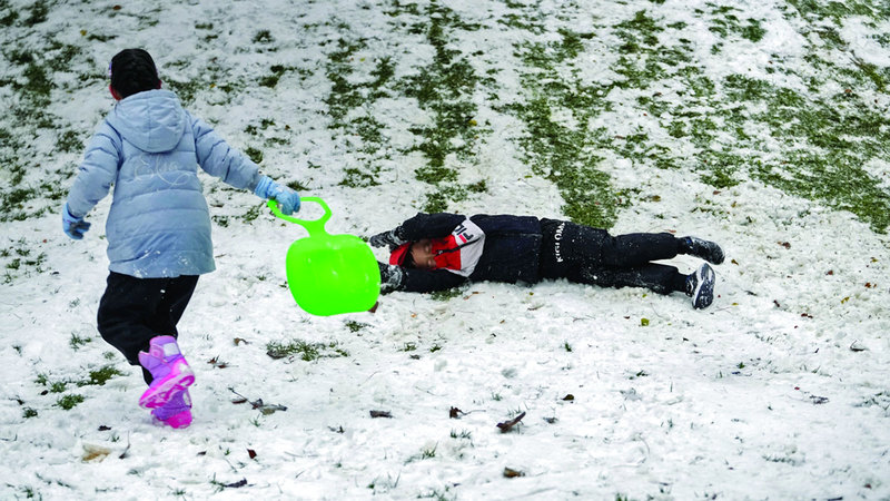 أطفال يلعبون في الثلوج بعد العاصفة الثلجية التي ضربت العاصمة الصينية بكين. أ.ف.ب