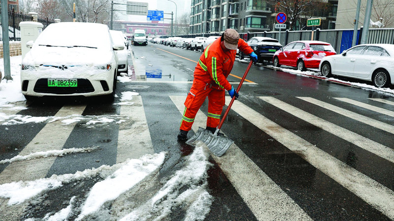 عمال يزيحون الثلوج من الطرقات. رويترز