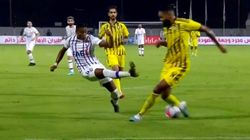 تدخُّل لاعب العين جوناتاس مع مدافع اتحاد كلباء والاس سانتوس.