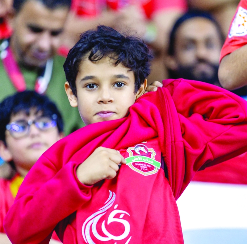 مشجع شباب الأهلي فخور بشعار ناديه. من المصدر