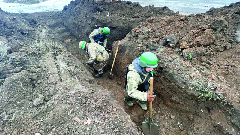 جنود أوكرانيون محاصرون في حقل خارج  باخموت يحفرون خندقاً للحماية. أرشيفية