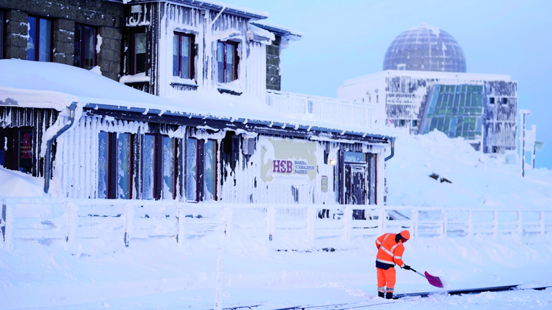 عامل ينظف الثلوج من أمام المنازل. أ.ب