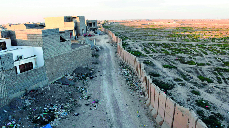 تلاصق السور بيوت من الطوب  ومن الجانب الآخر تمتدّ مساحات شاسعة من الأراضي الفارغة نمت فيها الأعشاب البرية. أ.ف.ب