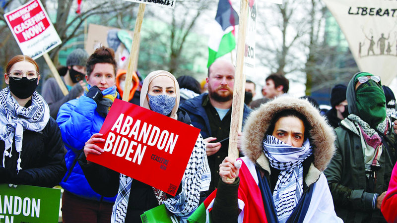 متظاهرة تحمل لافتة كتب عليها «تخلوا عن بايدن». رويترز