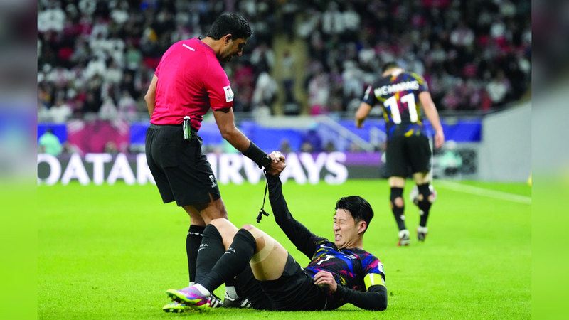 الحكم محمد عبدالله يساعد قائد منتخب كوريا سون على النهوض. أ.ف.ب