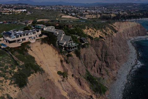 صورة جوية تظهر المنازل على حافة منحدر فوق المحيط الهادئ بسبب انهيار أرضي بعد هطول أمطار غزيرة في دانا بوينت، كاليفورنيا