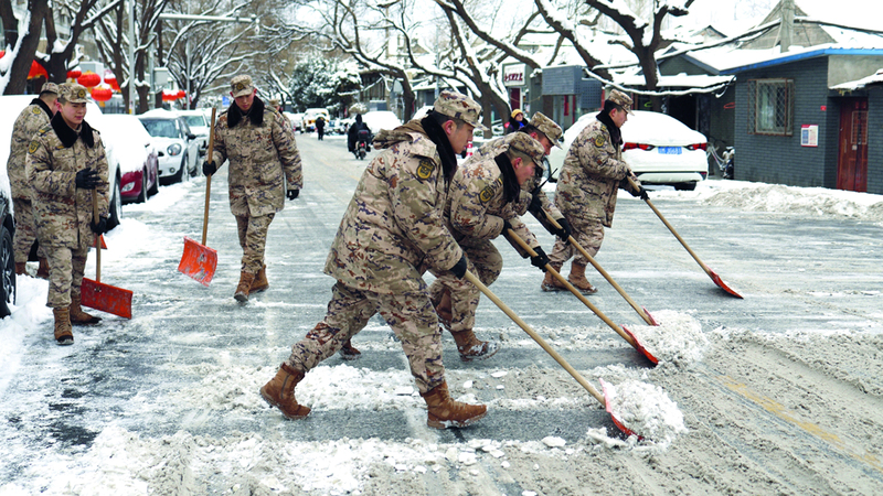 قوات شبه عسكرية تزيح الثلوج عن الشوارع. رويترز