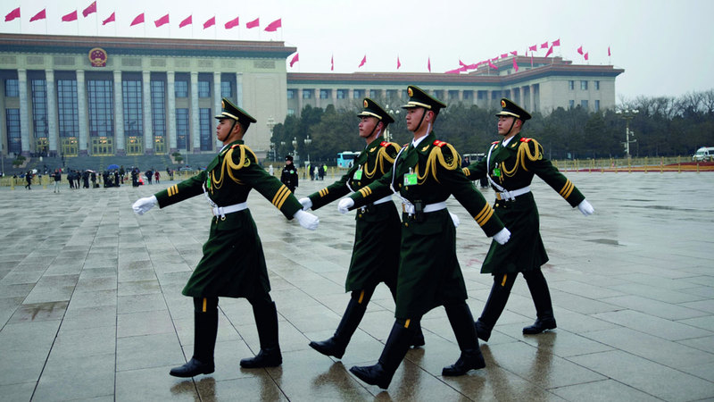 جنود يستعرضون أمام مبنى البرلمان الصيني. إي.بي.إيه