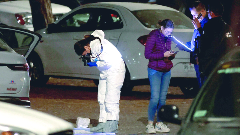 أفراد من الطب الشرعي والشرطة يفحصون الأدلة التي تم العثور عليها في سيارة الصحافي. أ.ف.ب