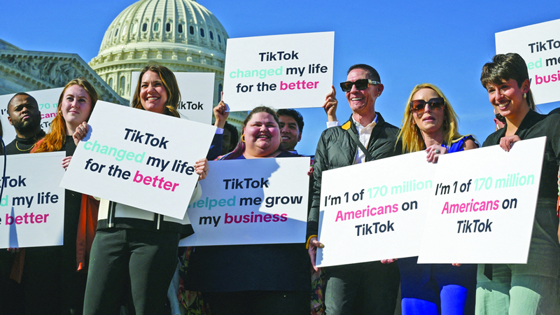 شباب أميركيون يرفعون لافتات تعبر عن رفضهم مشروع قانون حظر «تيك توك». رويترز