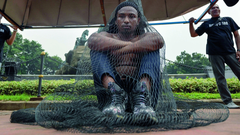 صياد يحتج من خلال وضع نفسه داخل شبكة صيد. أ.ف.ب