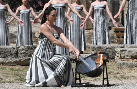 الممثلة اليونانية ماري مينا، التي تلعب دور الكاهنة الكبرى، تشعل الشعلة خلال بروفة حفل إيقاد شعلة أولمبياد باريس 2024 في معبد هيرا القديم بموقع أولمبيا الأثري، مهد الألعاب الأولمبية القديمة في جنوب اليونان. الصور عن وكالات