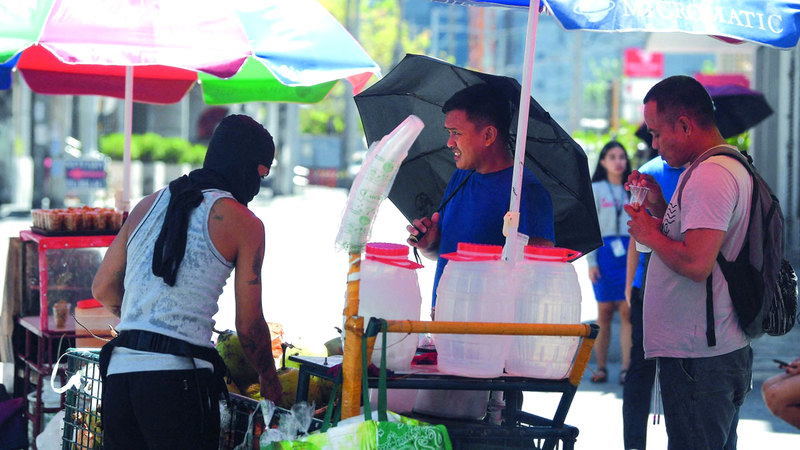 أشخاص يشترون شراب جوز الهند لتبريد أجسادهم. أ.ف.ب.