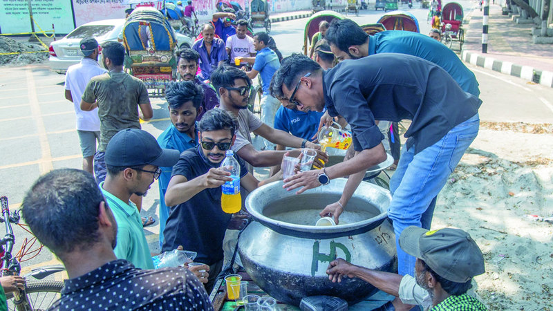 مواطن يوزع المثلجات مجاناً للمارة في أحد شوارع العاصمة دكا. إي.بي.ايه