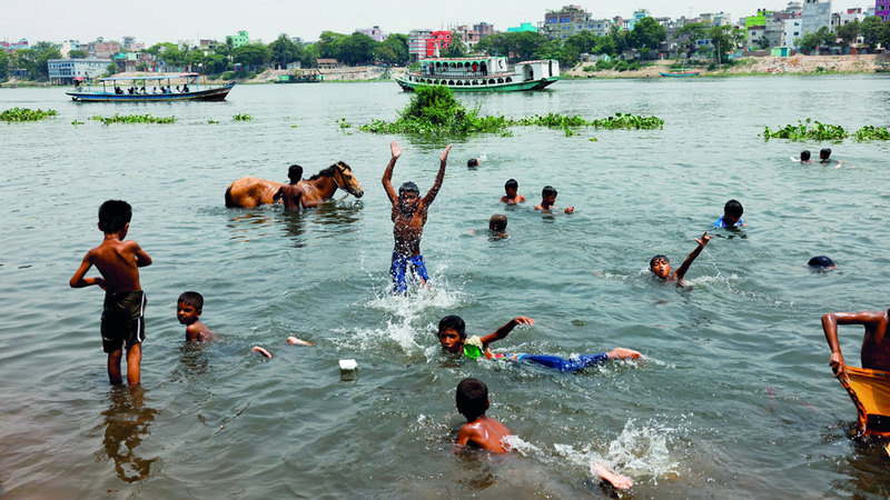 صبية يلعبون في الماء لتبريد أجسادهم بعد موجة الحر في البلاد. رويترز