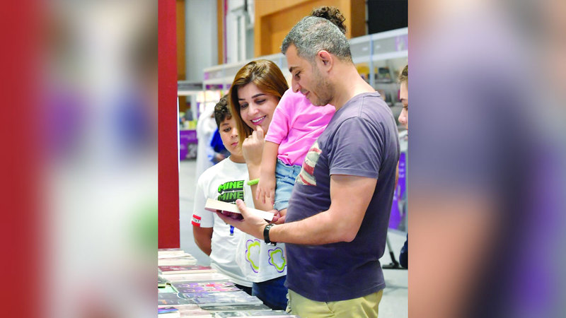 أسرة تتصفح الكتب في المعرض. تصوير: نجيب محمد