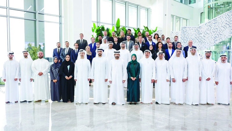 حمدان بن محمد في لقطة جماعية مع العاملين في المجمع. من المصدر