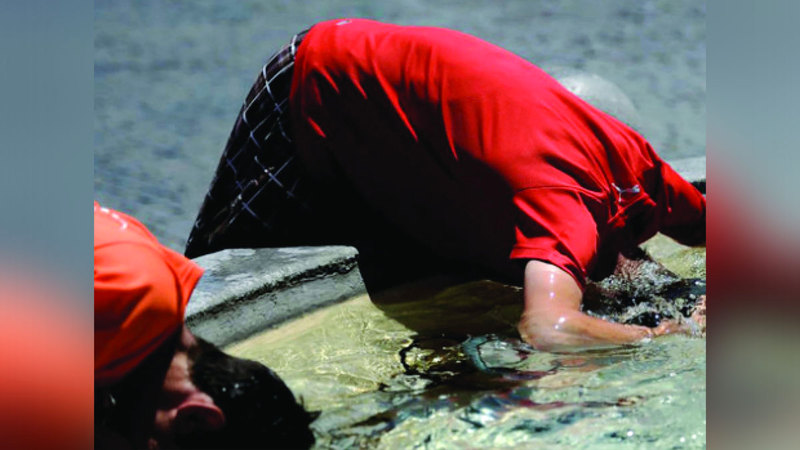 رجلان يغمران رأسيهما في الماء من شدة الحر التي تجاوزت التوقعات. أ.ف.ب