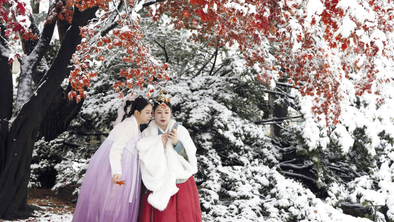 شابتان حرصتا على التقاط صورة «سيلفي» في سيؤول وسط الثلوج. إي.بي.إيه