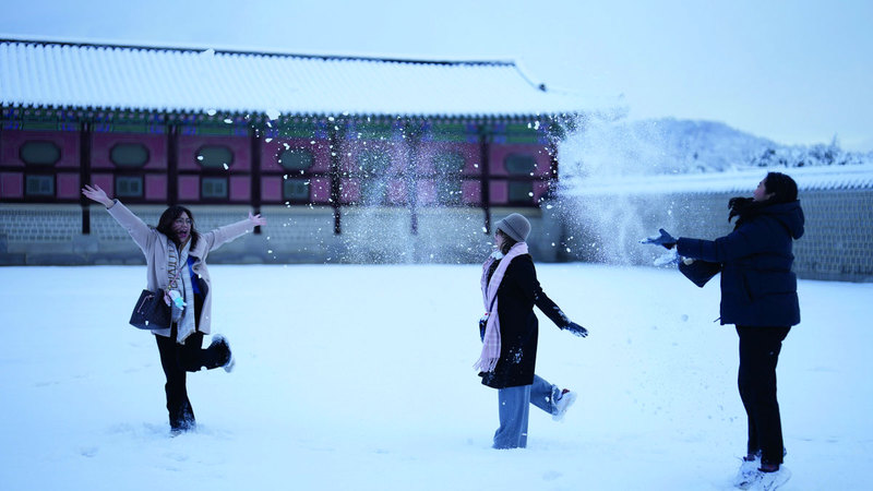 مواطنتان تستمتعان بالثلوج وسط سيؤول. أ.ف.ب